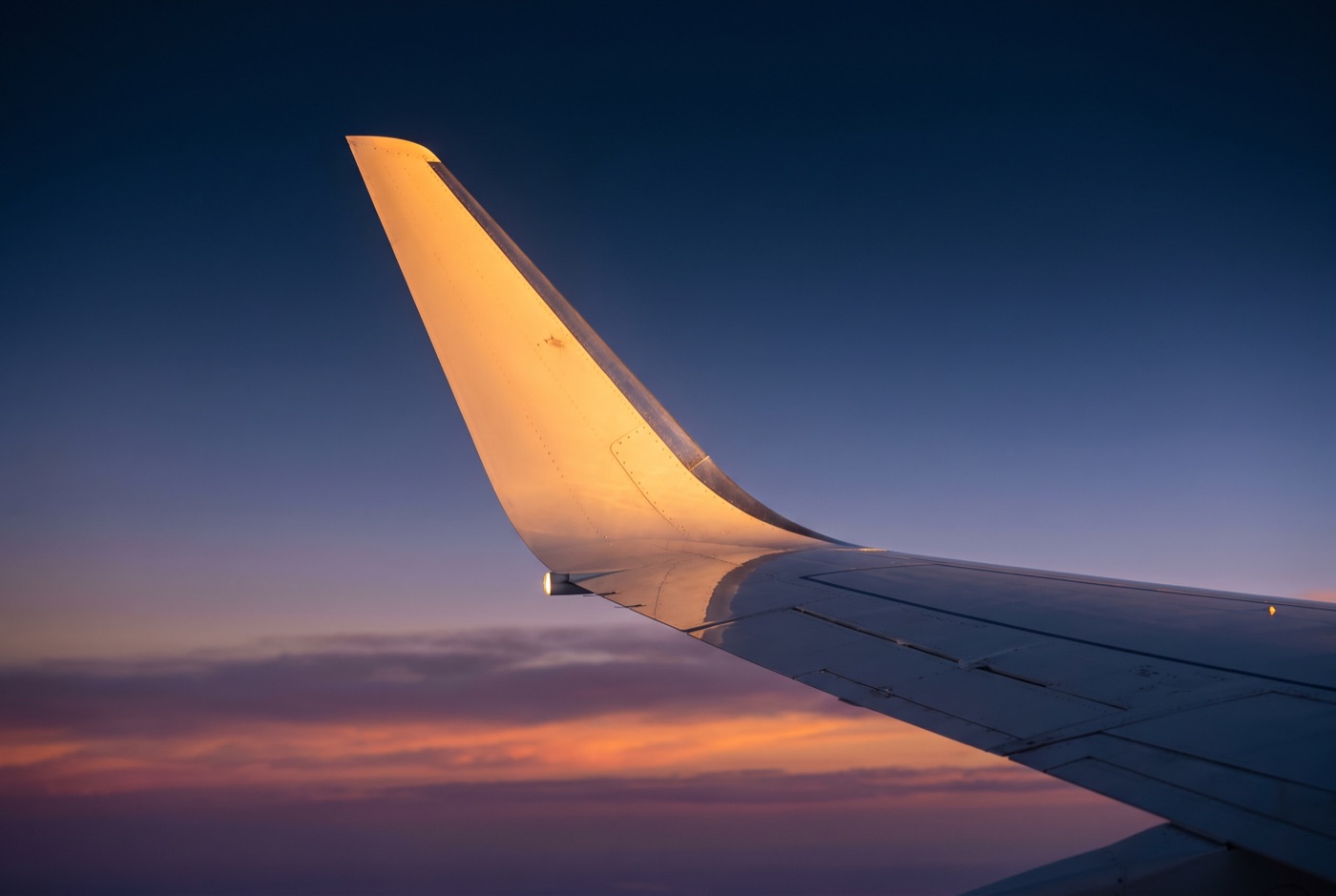 Business jet winglet catching the last golden light at dusk